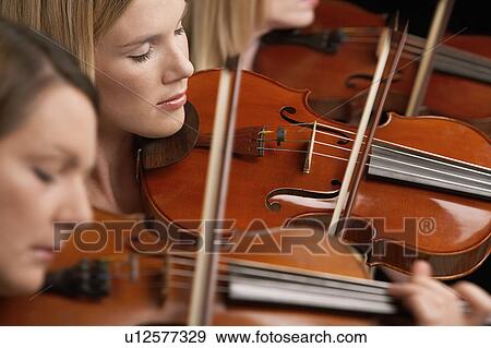 Women Playing Violins in musical group, close-up View Large Photo Image Stock Photo - Women Playing Violins in musical group, close-up. Fotosearch