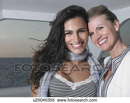 Stock Photography - Young and middle-aged woman in boat, smiling. Fotosearch