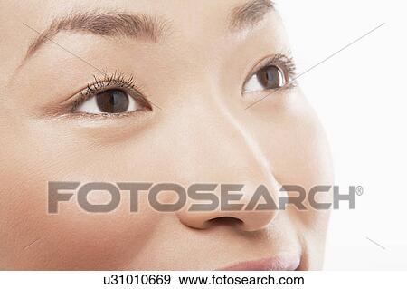 Stock Photo - Young Asian woman's face, looking up. Fotosearch