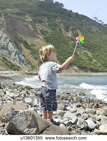 Stock Photography - Young boy holds pinwheel to wind, CA. Fotosearch