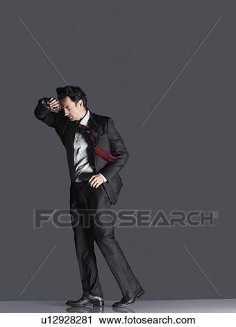 Young Businessman shielding face with arm from wind, side view View Large Photo Image Stock Image - Young Businessman shielding face with arm from wind, side view. Fotosearch