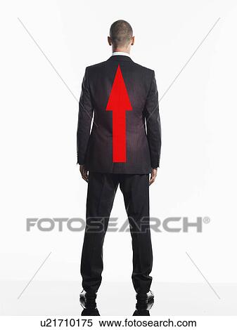 Stock Photography - Young businessman with red Arrow on Back, back view. Fotosearch