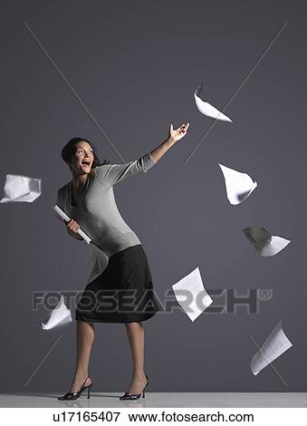 Stock Photo - Young Businesswoman with Scattering Papers, side view. Fotosearch