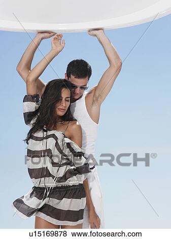 Stock Photo - Young couple dancing against sky. Fotosearch