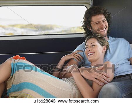 Stock Image - Young couple embracing in back of van. Fotosearch