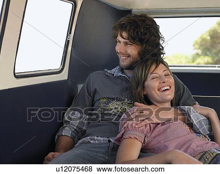 Stock Photo - Young couple embracing in back of van. Fotosearch