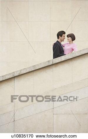 Stock Image - Young couple embracing on stairway. Fotosearch
