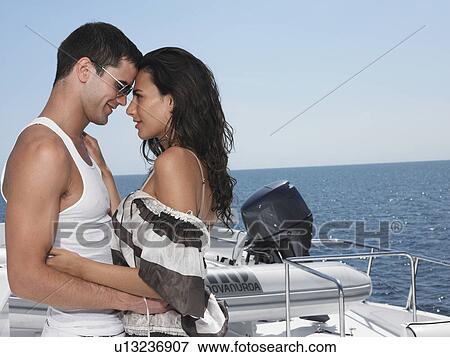 Stock Photo - Young couple embracing on yacht, profile. Fotosearch
