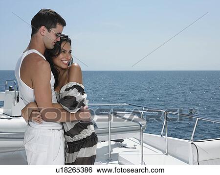 Stock Photograph - Young couple embracing on yacht. Fotosearch