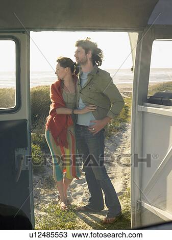 Young couple embracing, view through open door of camper van View Large Photo Image Stock Image - Young couple embracing, view through open door of camper van. Fotosearch