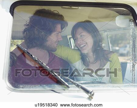 Stock Image - Young couple in van, view through window screen. Fotosearch