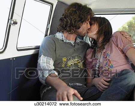Stock Image - Young couple kissing in back of van. Fotosearch