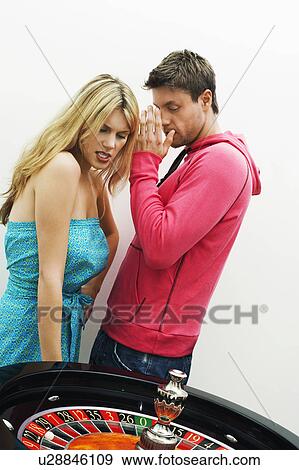 Stock Photo - Young Couple losing on roulette wheel. Fotosearch