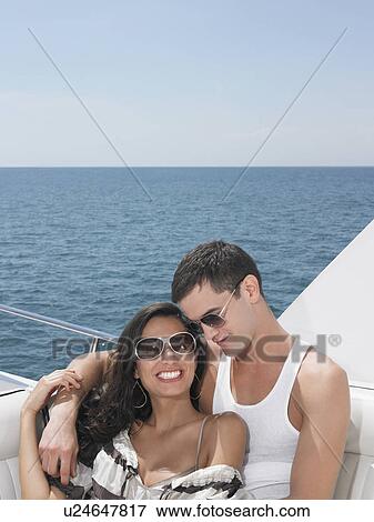 Stock Photo - Young couple relaxing on yacht at sea. Fotosearch