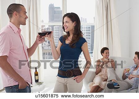 Young couples drinking wine in living room View Large Photo Image Stock Photography - Young couples drinking wine in living room. Fotosearch