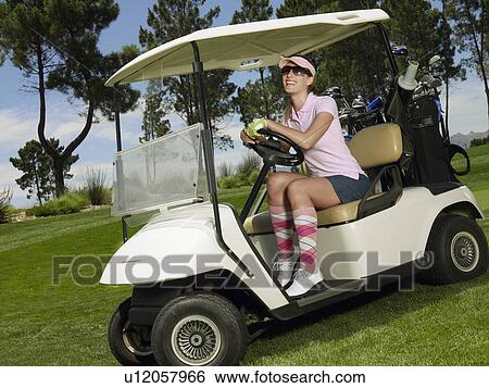 Young female golfer in sitting in cart, smiling View Large Photo Image Stock Photograph - Young female golfer in sitting in cart, smiling. Fotosearch