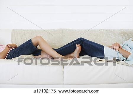 Young girl and mother lying down on couch, low section View Large Photo Image Stock Photography - Young girl and mother lying down on couch, low section. Fotosearch