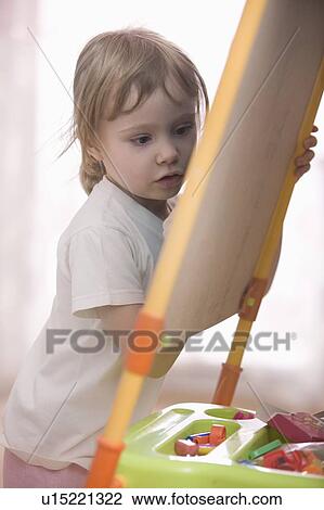 Stock Image - Young girl drawing on chalkboard. Fotosearch