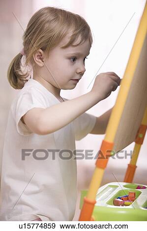 Young girl drawing on chalkboard View Large Photo Image Stock Photo - Young girl drawing on chalkboard. Fotosearch