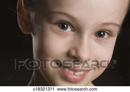 Stock Image - Young girl smiling at camera. Fotosearch