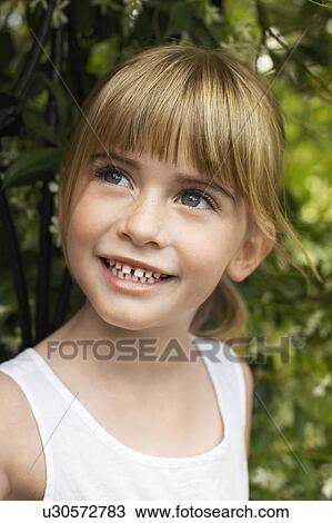 Stock Image - Young girl wearing tank top, smiling, portrait. Fotosearch