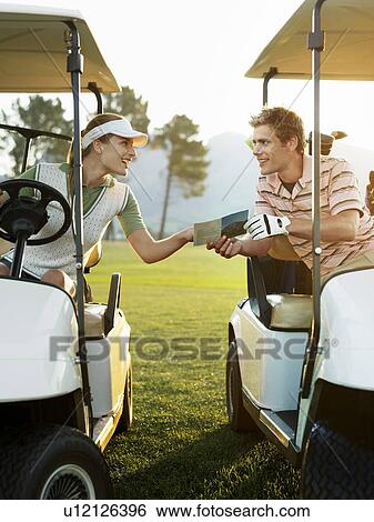 Young golfers sitting in golf cart, holding score card View Large Photo Image Stock Photograph - Young golfers sitting in golf cart, holding score card. Fotosearch
