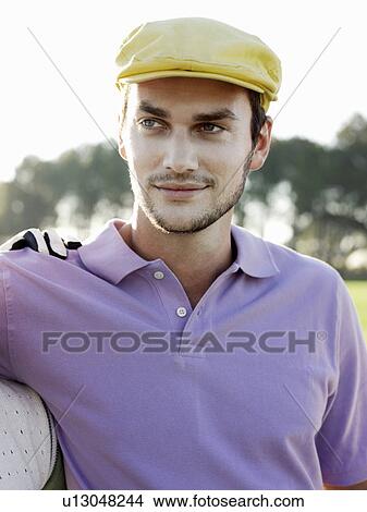 Picture - Young male golfer on course, portrait. Fotosearch