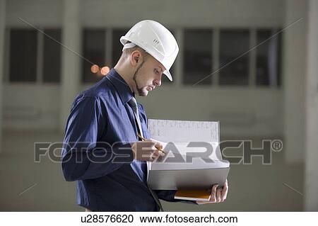 Stock Image - Young man holds documentation file. Fotosearch