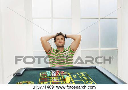 Young Man losing on roulette table View Large Photo Image Stock Photo - Young Man losing on roulette table. Fotosearch