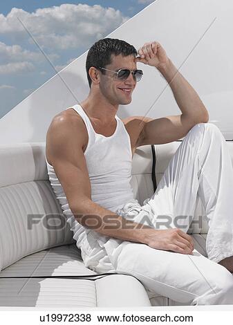 Stock Photo - Young man relaxing on yacht. Fotosearch