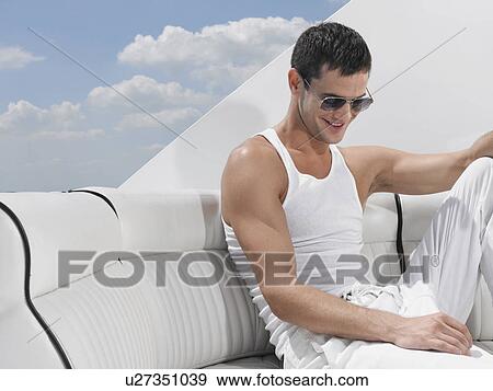 Young man relaxing on yacht View Large Photo Image Stock Photo - Young man relaxing on yacht. Fotosearch