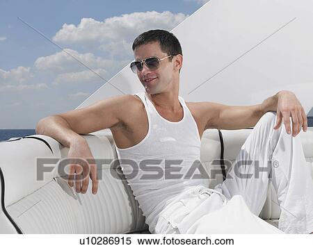 Stock Photography - Young man relaxing on yacht. Fotosearch