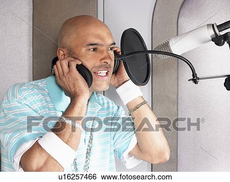 Young man singing in studio, portrait View Large Photo Image Stock Photograph - Young man singing in studio, portrait. Fotosearch