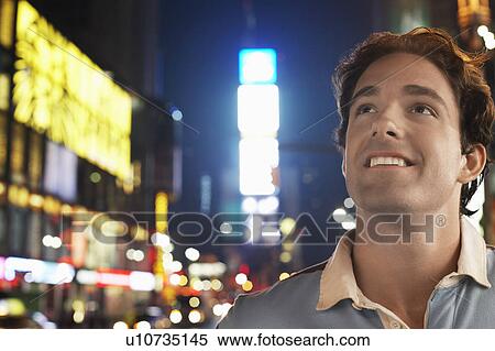 Young man standing in Times Square New York at night View Large Photo Image Stock Photography - Young man standing in Times Square New York at night. Fotosearch