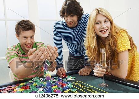 Young man with friends at roulette table playing with chips, portrait View Large Photo Image Stock Photography - Young man with friends at roulette table playing with chips, portrait. Fotosearch