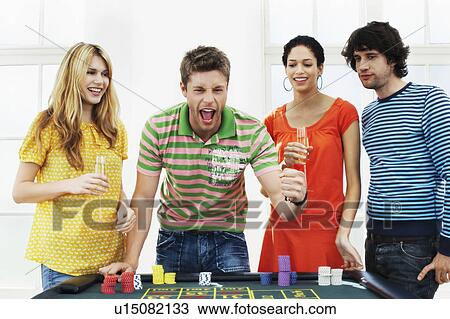 Young man with friends celebrating gambling win at roulette table View Large Photo Image Stock Image - Young man with friends celebrating gambling win at roulette table. Fotosearch