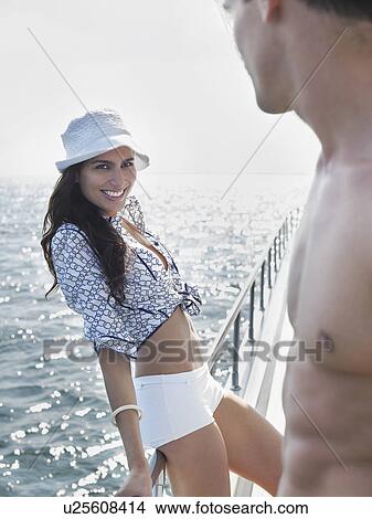 Picture - Young woman and man flirting on yacht. Fotosearch