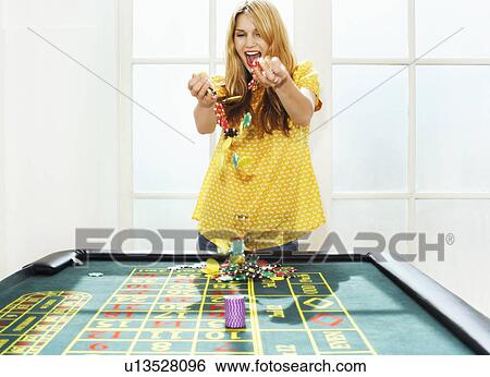 Young woman celebrating with chips on roulette table View Large Photo Image Stock Photograph - Young woman celebrating with chips on roulette table. Fotosearch