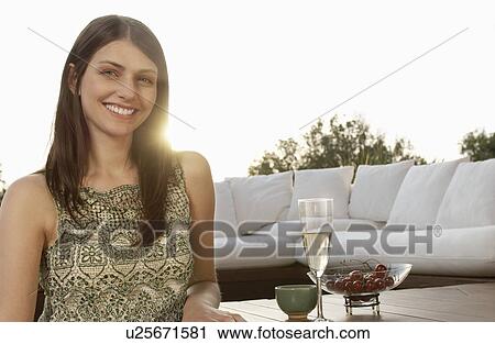 Young woman drinking champagne and eating fruit, portrait View Large Photo Image Stock Image - Young woman drinking champagne and eating fruit, portrait. Fotosearch