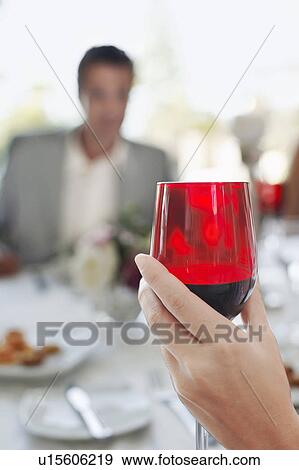 Stock Photo - Young woman holding wineglass, close-up. Fotosearch