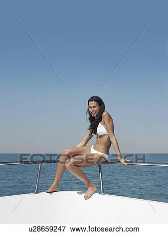 Young woman in bikini sitting on bow of yacht, portrait View Large Photo Image Stock Photo - Young woman in bikini sitting on bow of yacht, portrait. Fotosearch