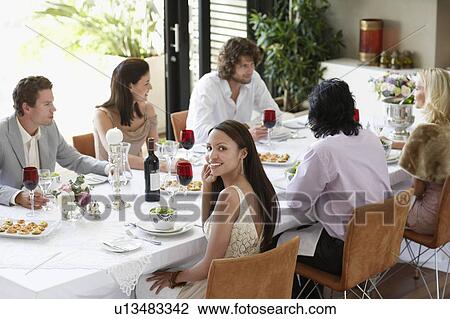 Young woman in dress sitting at table of formal dinner party, elevated view View Large Photo Image Stock Image - Young woman in dress sitting at table of formal dinner party, elevated view. Fotosearch