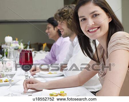Young woman in dress sitting at table of formal dinner party, side view View Large Photo Image Stock Image - Young woman in dress sitting at table of formal dinner party, side view. Fotosearch