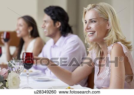 Young woman in dress sitting at table of formal dinner party, laughing, side view View Large Photo Image Stock Image - Young woman in dress sitting at table of formal dinner party, laughing, side view. Fotosearch