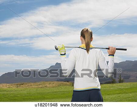 Stock Photo - Young woman on golf course, back view. Fotosearch