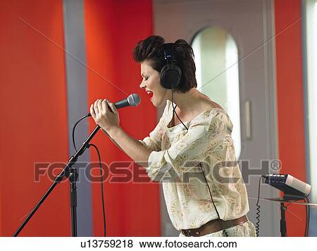 Young woman singing in studio, profile View Large Photo Image Stock Photo - Young woman singing in studio, profile. Fotosearch