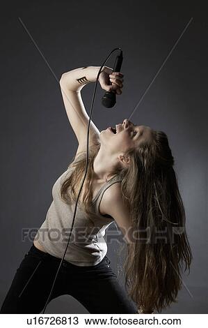 Young woman singing in studio View Large Photo Image Stock Image - Young woman singing in studio. Fotosearch