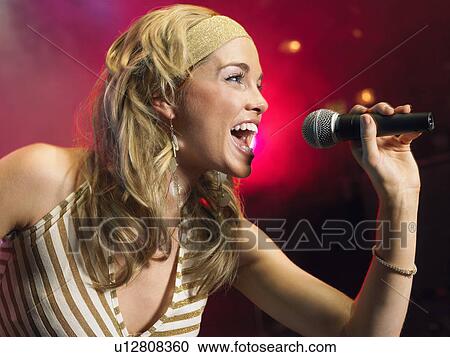 Young Woman Singing on stage in Concert, side view View Large Photo Image Stock Image - Young Woman Singing on stage in Concert, side view. Fotosearch