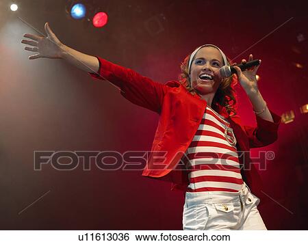 Stock Photograph - Young Woman Singing on stage in Concert, low angle view. Fotosearch