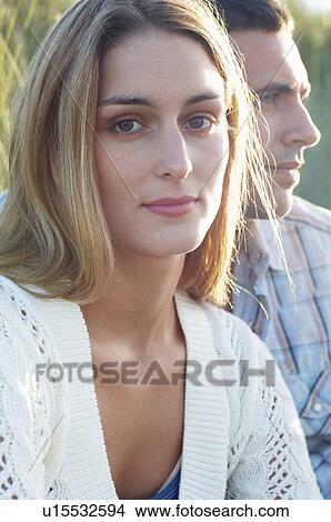 Young Woman Sitting by Boyfriend in tall grass, portrait View Large Photo Image Picture - Young Woman Sitting by Boyfriend in tall grass, portrait. Fotosearch